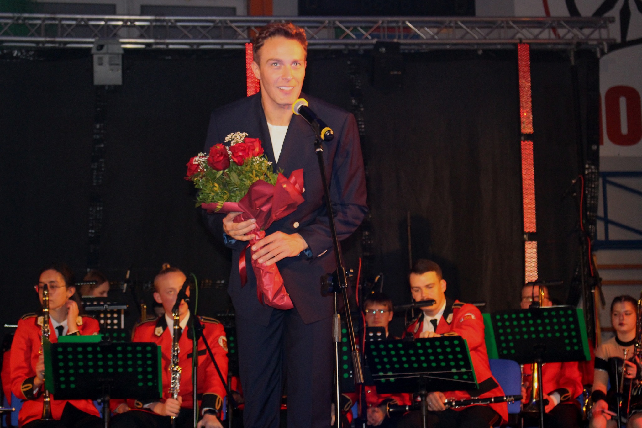 Wokalista Sławek Uniatowski z bukietem kwiatów na scenie w hali MOSiR w Kole