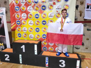 Marcin Szwast na podium z biało-czerwoną flagą