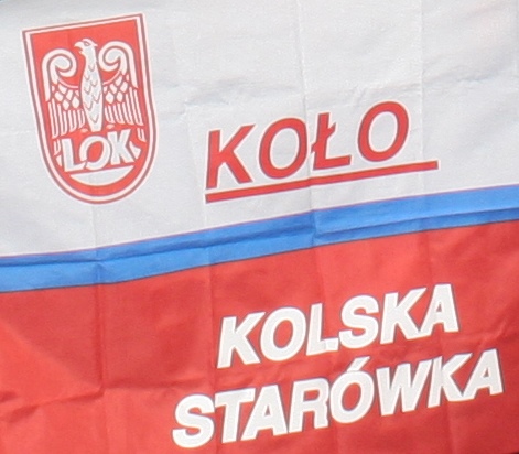 Zdjęcie przedstawia flagę narodową z logiem LOK.