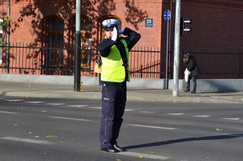 Zdjęcie przedstawia policjanta kierującego ruchem.