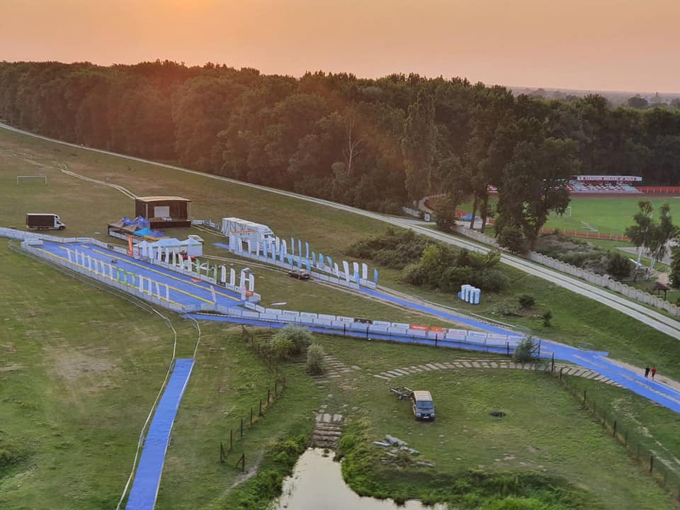 Zdjęcie z lotu ptaka terenu przystani kajakowej przy rzece warcie w Kole, w tle stadion miejski.