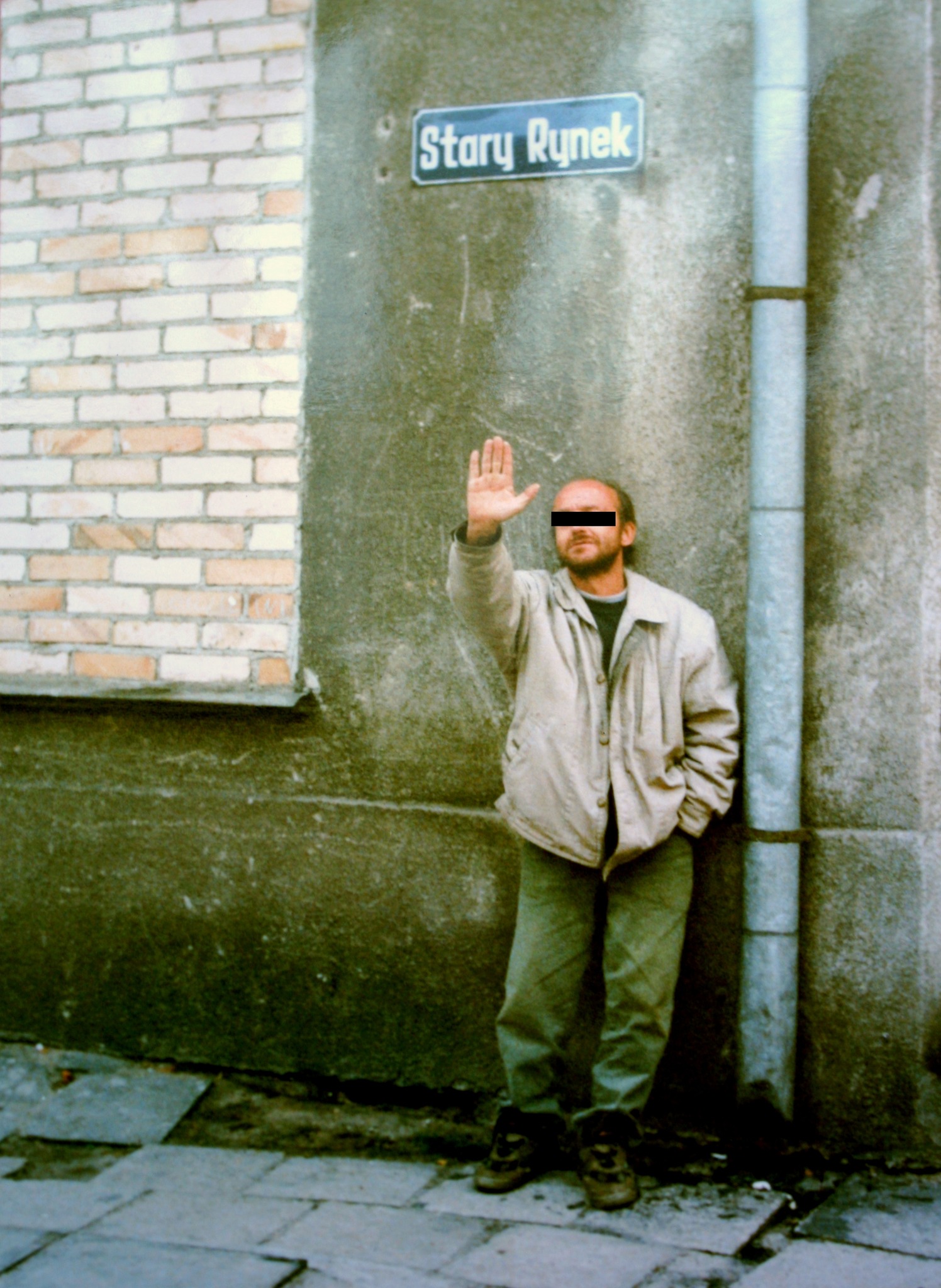 Mężczyzna z podniesioną dłonią na ulicy Stary Rynek w Kole