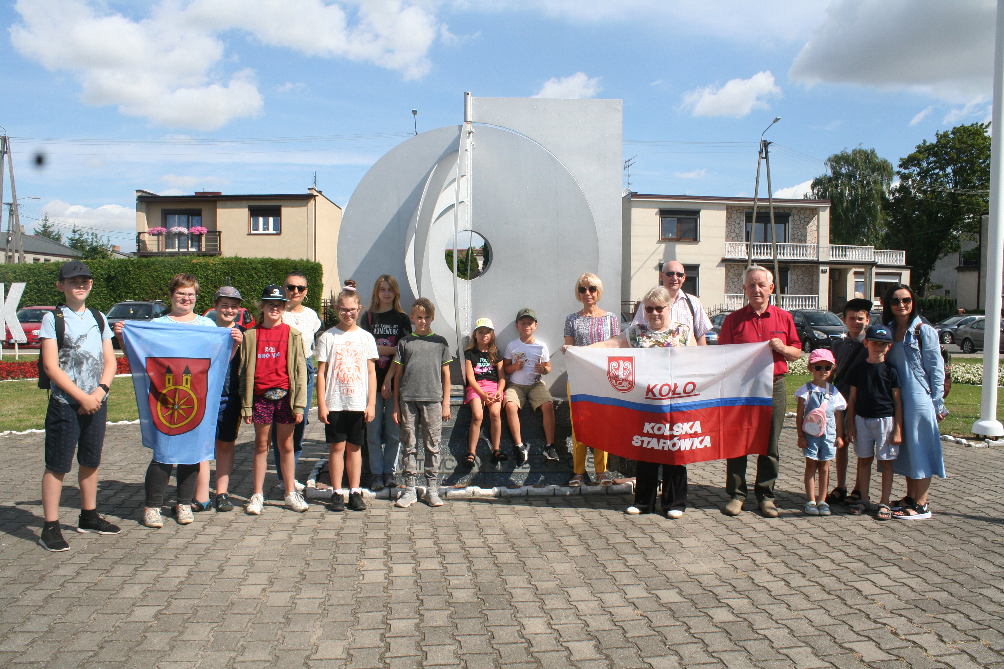 Uczestnicy wycieczki wakacyjne spotkanie z historią z flagą LOK KOLSKA STARÓWKA