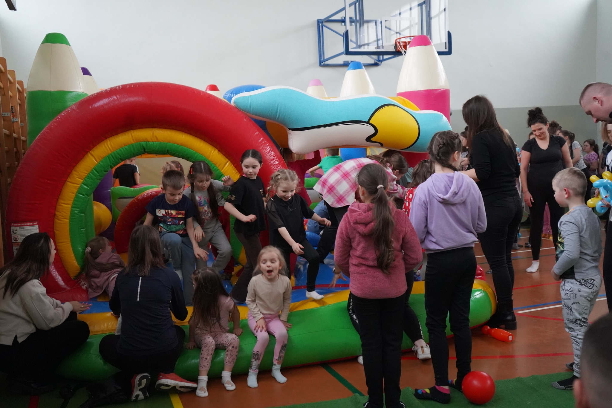 Dzieci bawiące się na dmuchanym zamku w sali gimnastycznej w Szkole Podstawowej nr 5