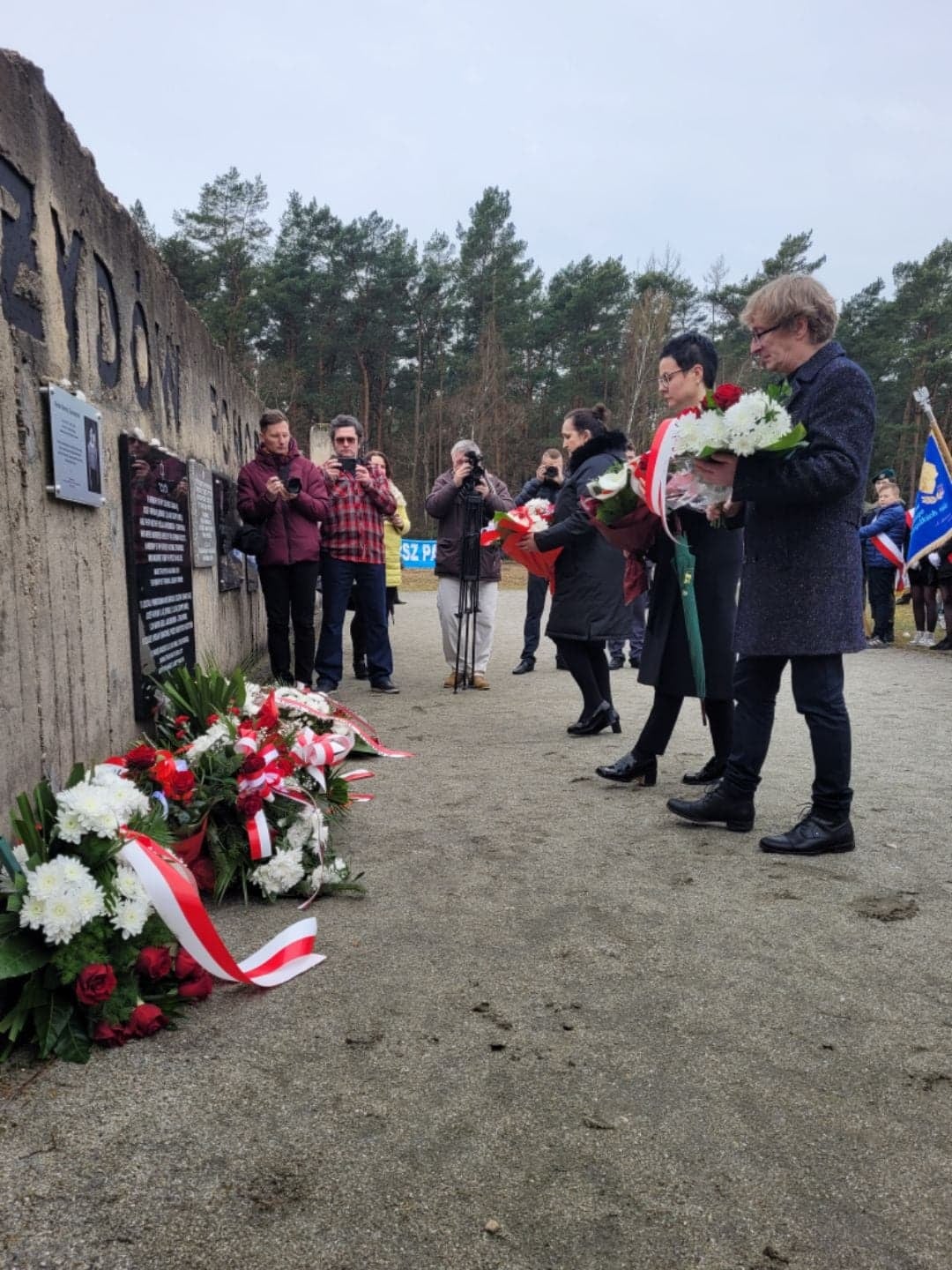 Sekretarz Miasta Monika Ciesielska i Dyrektor MDK w Kole Radomir Piorun składają wiązanki kwiatów.