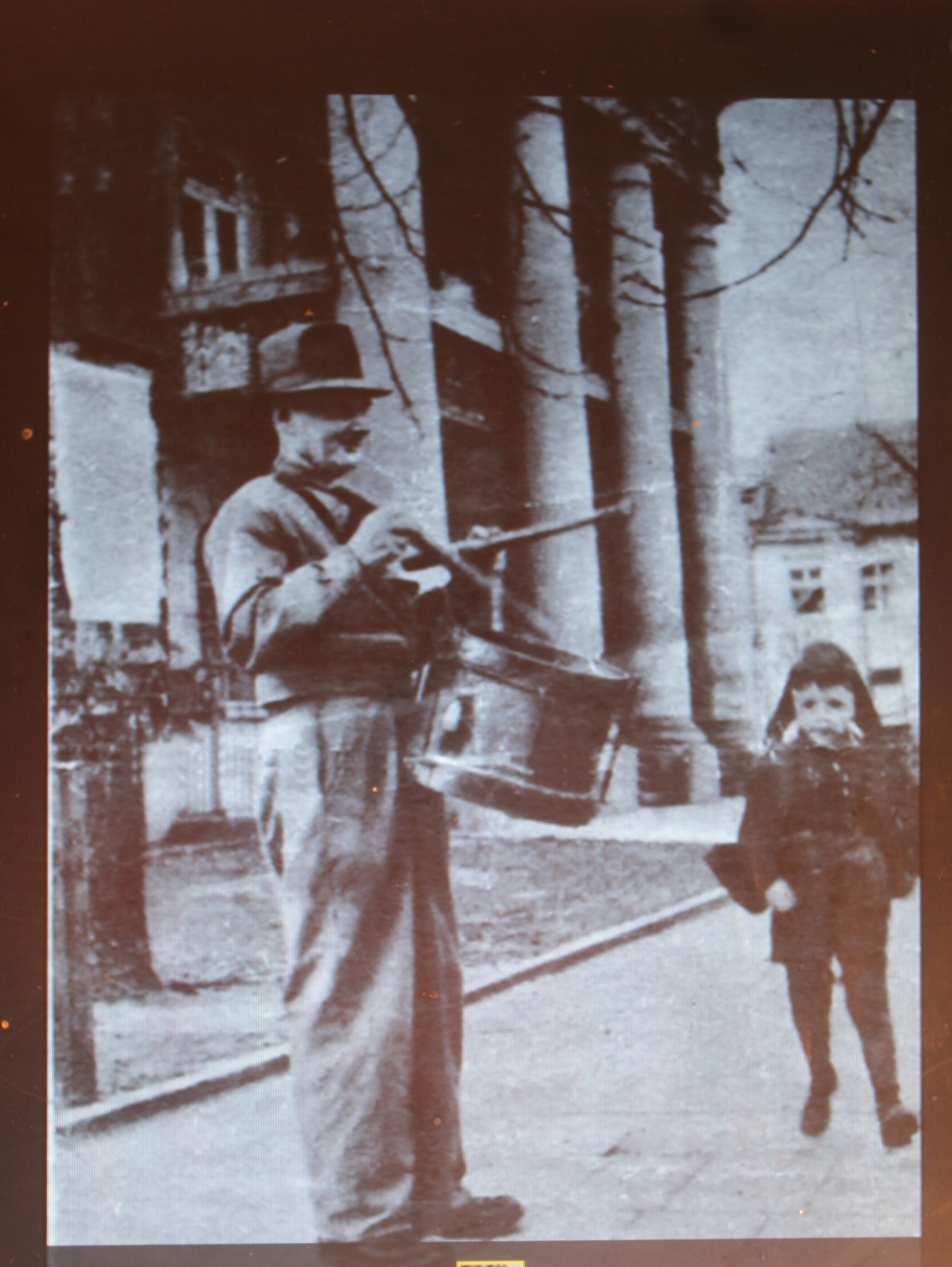 Zdjęcie Feliksa Lewandowskiego stojącego z bębenkiem przed Ratuszem w Kole