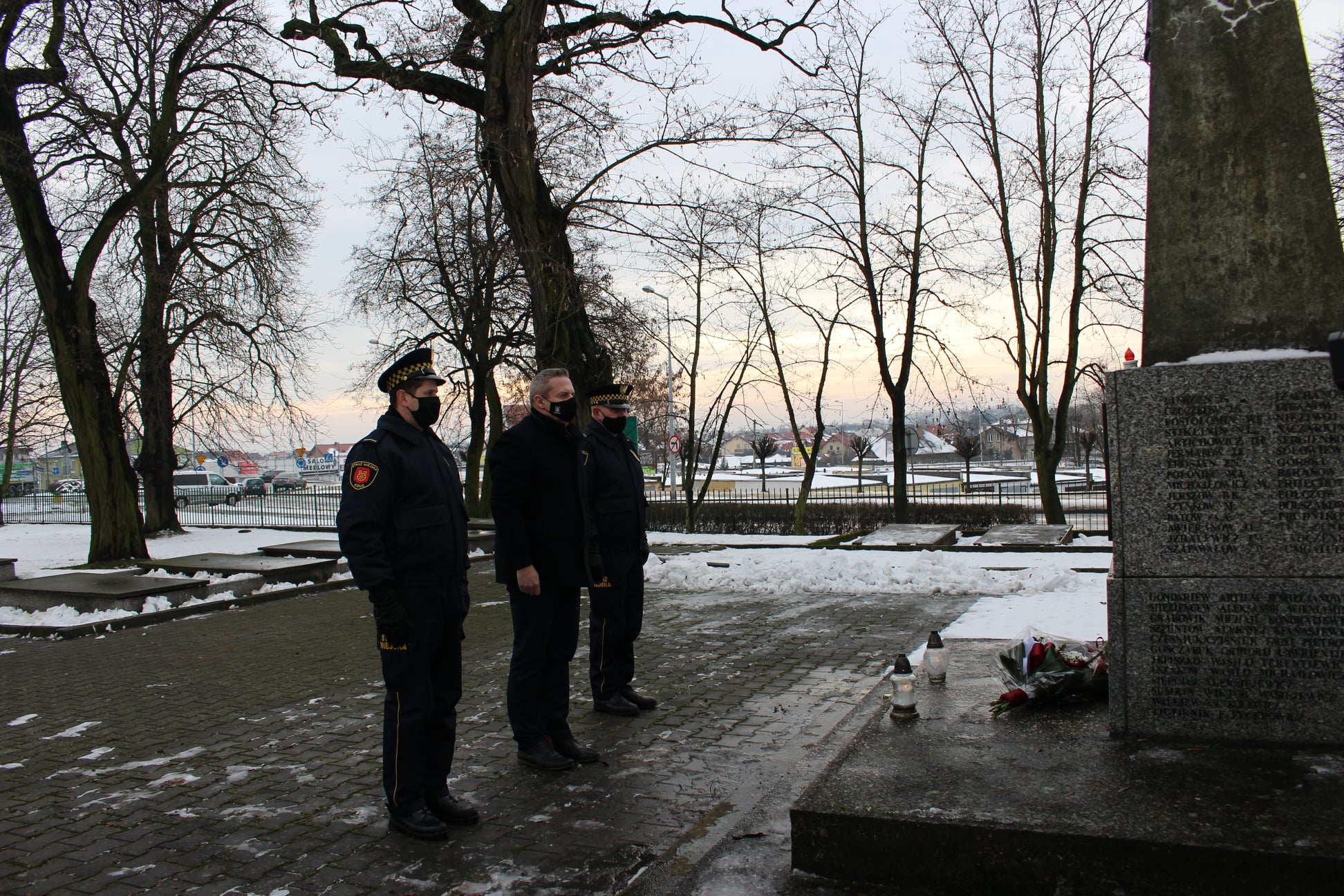 Zdjęcie przedstawia Burmistrza Miasta Koła w asyście strażników miejskich na Cmentarzu Wojennym.
