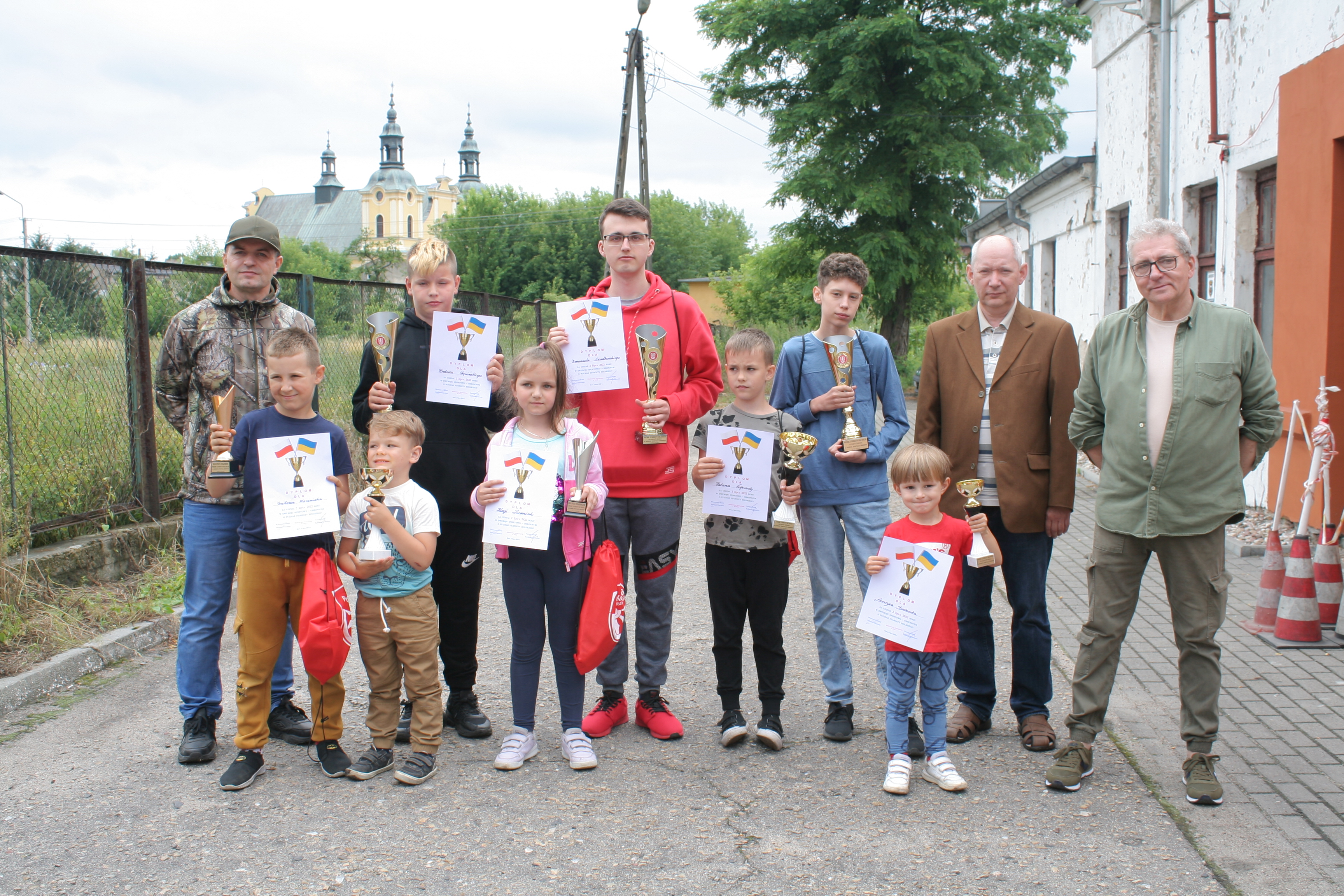 Zdjęcie grupowe uczestników Dwuboju Sportowo-Obronnego z dyplomami i pucharami.