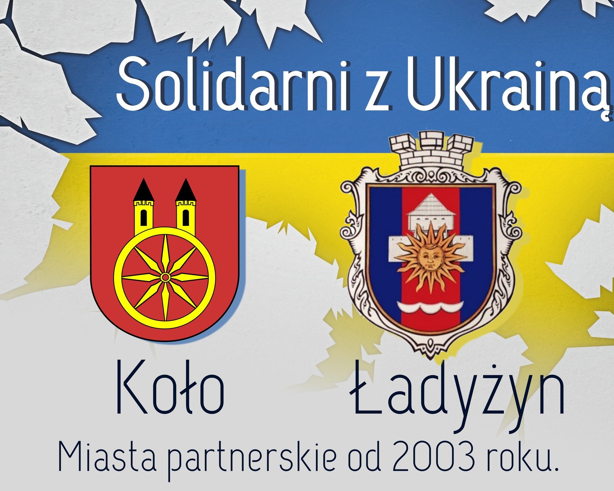 Na planszy widnieje hasło Solidarni z Ukrainą na tle flagi Ukrainy. Po obu stronach znajdują się herby dwóch miast partnerskich: Koło z Polski (po lewej) i Ładyżyn z Ukrainy (po prawej). Na dole planszy napis: Miasta partnerskie od 2003 roku