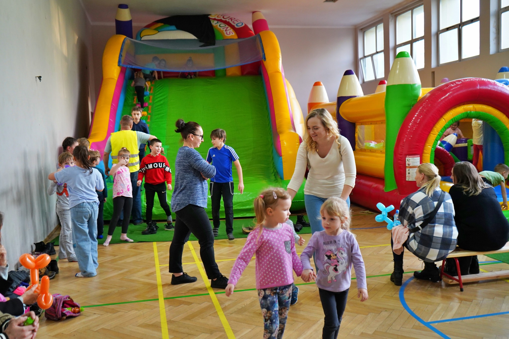 Dzieci bawiące się na dmuchanym zamku w sali gimnastycznej w Szkole Podstawowej nr 2